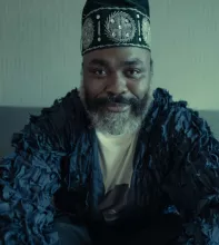Nduduzo Makhathini sitting in a blue shirt and wearing a black turban