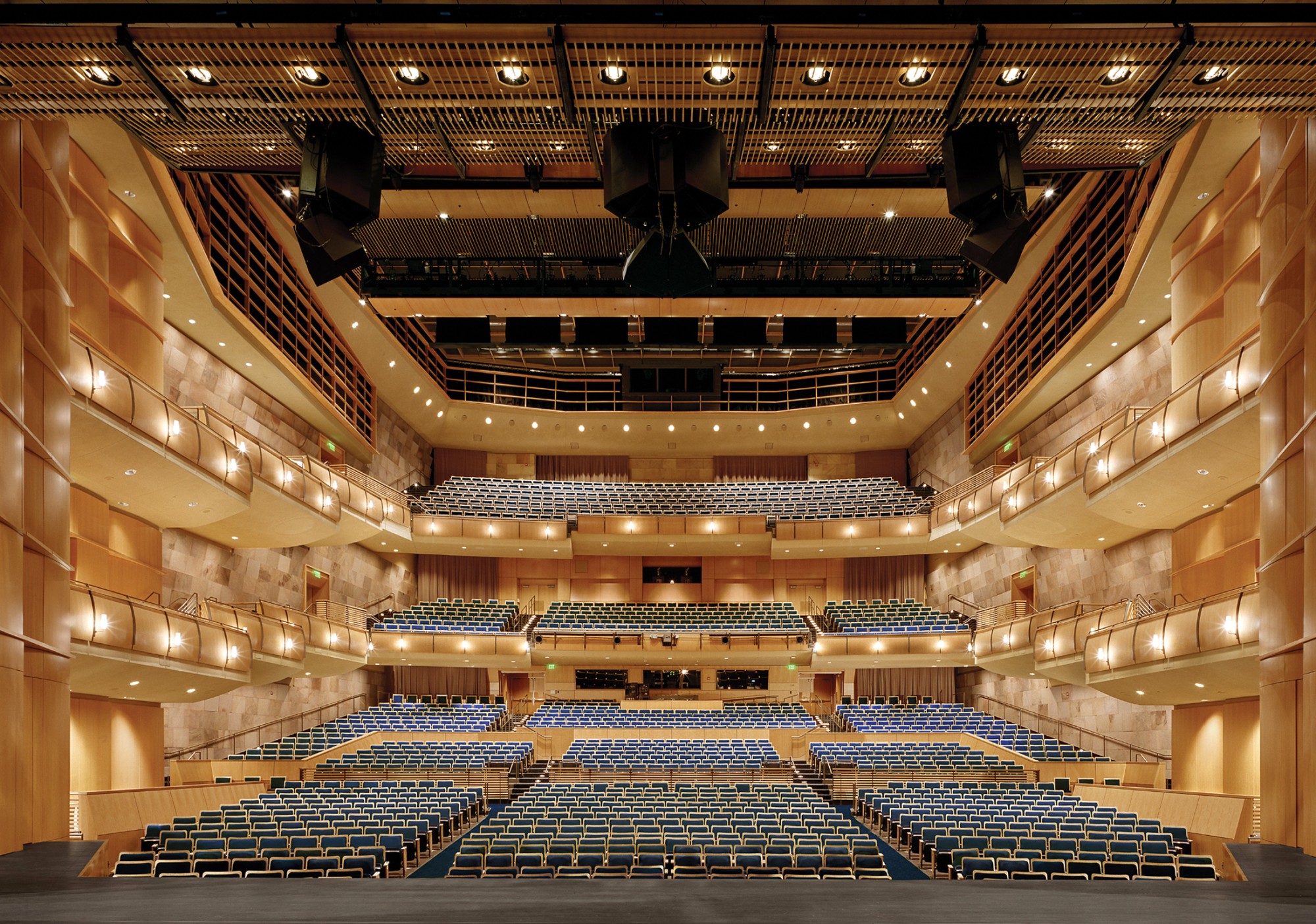 A spacious Jackson Hall with multiple levels of seats, warm lighting, and wooden accents.