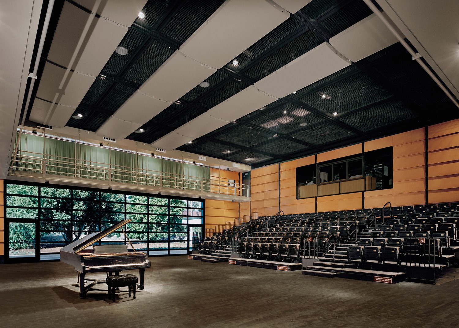 Studio theatre featuring a grand piano and tiered seating under bright lights.