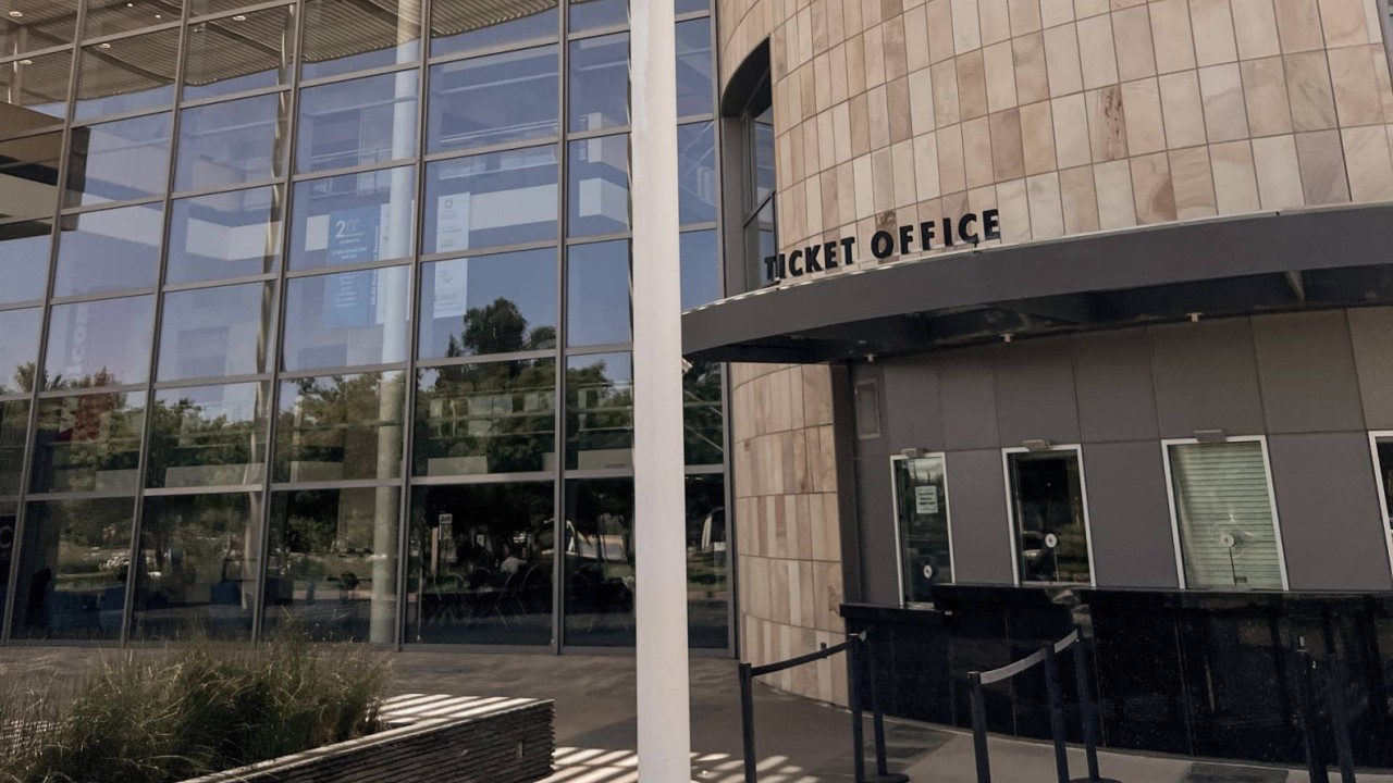 Mondavi Center ticket office with a stone facade and large glass windows in a landscaped area.