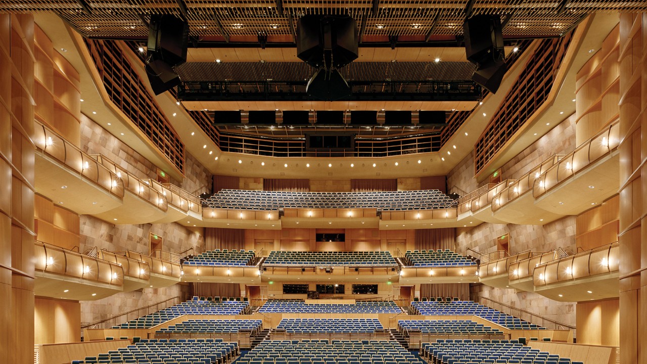 Jackson Hall view from stage with seats and tiers showing and lights on.