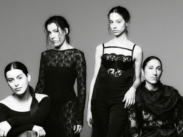 Black-and-white photo of Las Migas in elegant black dresses.
