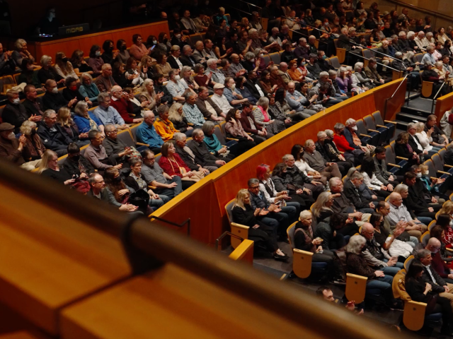 Audience members sit in Jackson Hall waiting for performance to begin