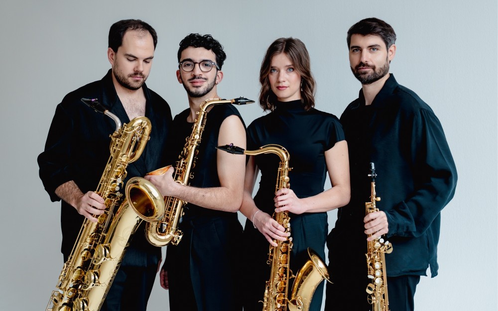 Arcis musicians holding their instruments, dressed in black against a light background.