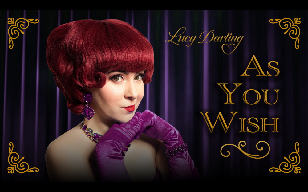 Vintage poster of coy red-haired woman in purple gloves before a purple velvet curtain with the text "Lucy Darling As You Wish" overlaid on top.