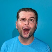 A man with silly, dumbfounded, open-mouthed expression on a bright blue background.