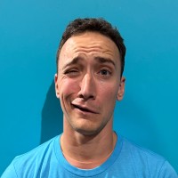 Young man with exaggerated confused face against bright blue background