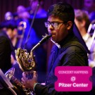 Musician playing saxophone horn on purple-lit stage, pink event graphic with the text "Concet happens @ Pitzer Center"